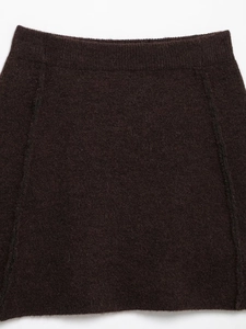 Macro detail of dark brown knit skirt showing elastic waistband and wool texture