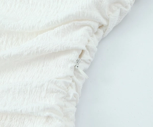 Macro detail of high-quality invisible zipper on textured white fabric dress