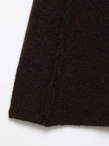 Detailed macro view of dark coffee wool knit fabric showing soft texture and stitching