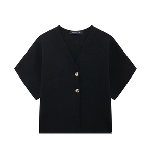 Detail of V-neck knitted top with two decorative gold buttons and ribbed texture