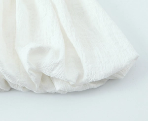Macro shot of white pleated seersucker fabric texture for an elegant summer dress