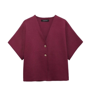 Detailed view of the V-neck knit top with two amber textured buttons in burgundy red