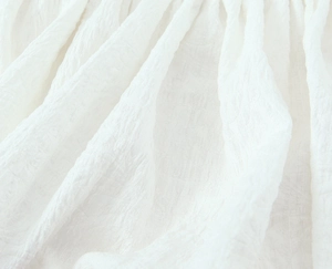 Close-up of white textured crepe fabric detail with three-dimensional wrinkled texture