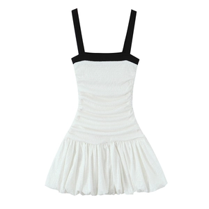 Detail view of the black contrast straps and horizontal ruched bodice on the dress