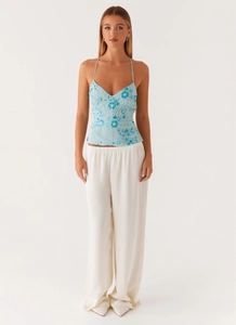 Detail of light blue camisole with floral embroidery and white beadwork on the front