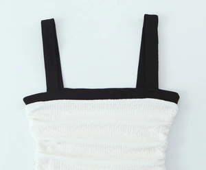 Detail of contrast square neck strap and white crinkled textured fabric on dress