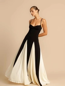 Dettaglio di un elegante abito lungo a pieghe bianco e nero con spalline sottili e stile