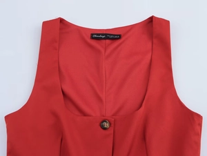 Detail shot of the red sleeveless vest showing square neckline and dark wood button