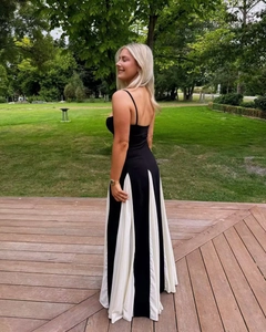 Dettaglio di un elegante abito lungo a pieghe bianco e nero con spalline sottili