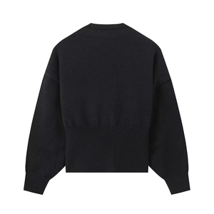 Detail of black knit sweater featuring ribbed hem and sleeve cuffs for a slim fit