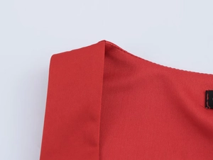 Detailed macro shot of red top featuring contrast stitching and mixed textured fabrics
