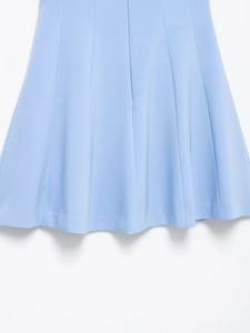 Détail de l'ourlet d'une jupe évasée bleu clair montrant plis verticaux et coutures nettes