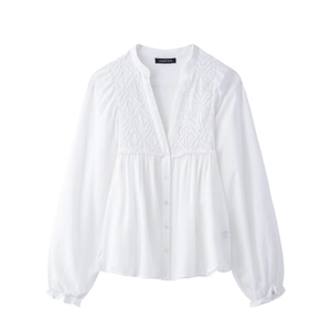 Detail of white lantern sleeve shirt with delicate geometric embroidery and stand collar