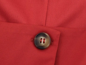 Close-up of bright red sleeveless vest fabric texture and premium faux horn button detail