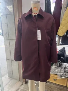 Detail view of the burgundy long-sleeved lapel coat texture and premium size tag information