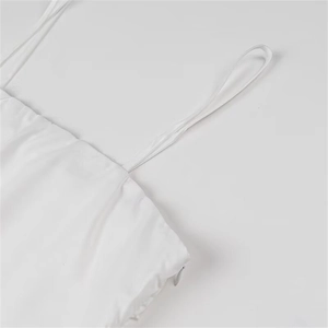 Detail eines eleganten weißen Trägerkleids mit dünnen Trägern und verdecktem Reißverschluss