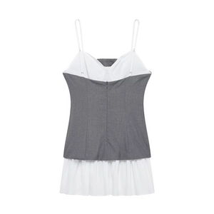 Detailed view of dark grey poplin mini dress with white pleated patchwork hem and thin straps