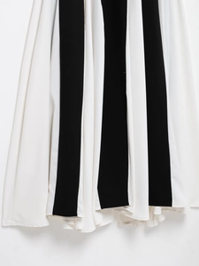 Dettaglio dell'elegante gonna a righe verticali bianche e nere con tessuto drappeggiato