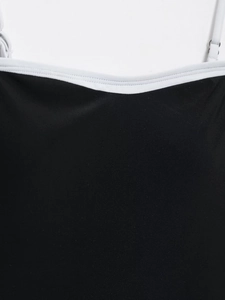 Detail view of black women's bodysuit with white trim and adjustable thin straps
