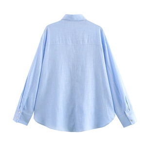 Detail view of the light blue linen shirt back featuring a curved hem and textured fabric