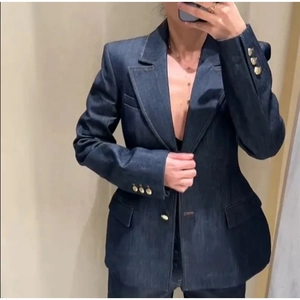 Détails rapprochés d'un blazer en denim bleu foncé avec boutons dorés élégants