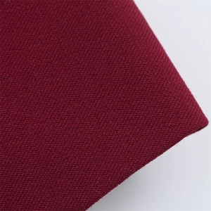 Gros plan détaillé montrant le tissage dense et la texture du tissu de costume bordeaux