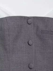 Close-up of grey waistcoat details with poplin stitching and fabric-covered buttons