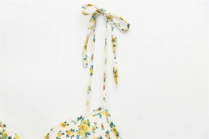 Close-up of floral print poplin dress showing delicate spaghetti straps and bow tie detail