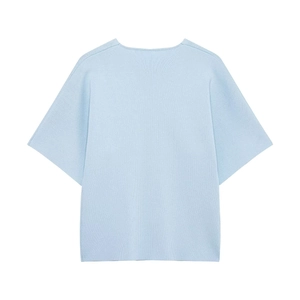 Detailed close-up of light blue knit top with two metal buttons and crew neck