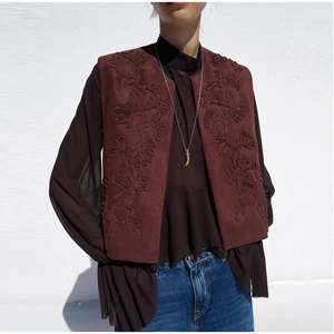 Detail of vintage burgundy suede vest featuring intricate tonal floral embroidery design
