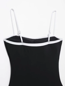 Detail view of adjustable white straps and contrast piping on black bodysuit top