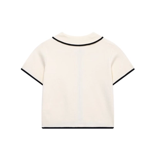 Back view of elegant ivory knit top with black contrast trim and vintage aesthetic
