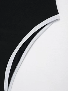 Detailed view of white piping and high-quality stitching on a black bodysuit edge