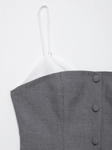 Detail of grey textured fabric with white trim, thin straps, and matching buttons
