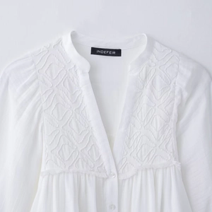Minimalist white V-neck long sleeve shirt featuring geometric embroidery and button detail