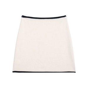 Detailed view of cream knit mini skirt with contrasting black trim and fine texture