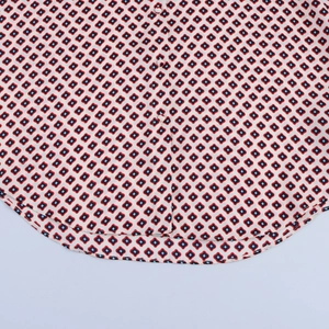 Detail of satin shirt showing geometric diamond print, white buttons and curved hemline
