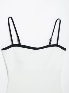 Detail of adjustable black straps and contrasting neckline on white bodysuit