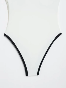 Detail of high-stretch white bodysuit featuring black contrast trim and fine stitching