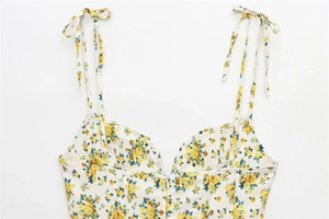 Detail of floral print poplin dress with adjustable tie straps and V-neckline
