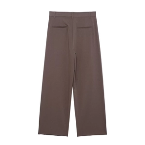Détail d'un pantalon taupe à taille haute avec passants de ceinture et poches passepoilées