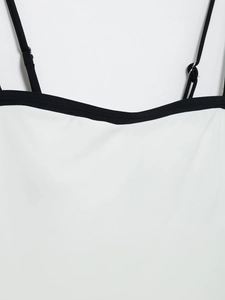 Detail of white bodysuit with black contrast piping and adjustable thin shoulder straps