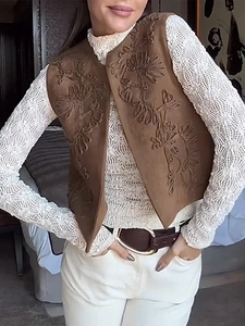 Detail of vintage embroidery and suede texture on a brown bohemian sleeveless vest