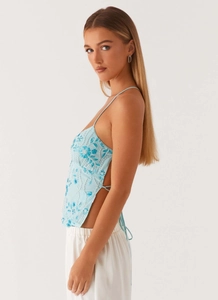 Détails de broderie de paillettes bleues et laçage au dos sur un top dos nu estival