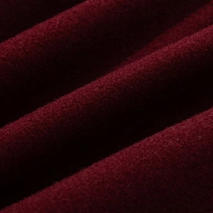 Macro close-up showing the rich texture of burgundy velvet fabric with elegant soft folds