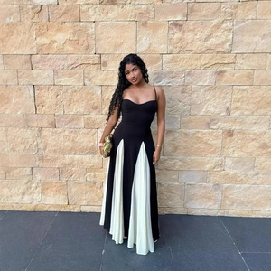 Elegante abito lungo bicolore bianco e nero con spalline sottili e gonna a pieghe fluida