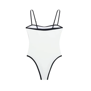 Detail view of white bodysuit with black piping, thin adjustable straps and high-cut leg