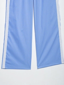 Primer plano detallado de pantalones de pierna ancha a rayas azules con encaje blanco