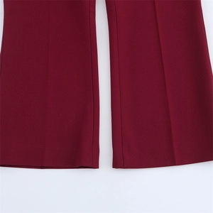 Vue détaillée du pantalon rouge vin avec plis marqués et finitions de l'ourlet nettes