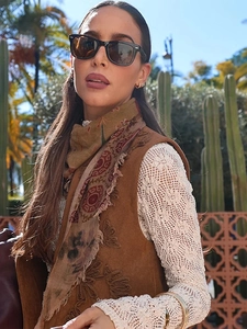 Detail of vintage brown suede vest with embroidery and bohemian lace top details